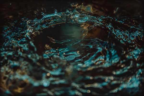Water ripples creating a rhythmic pattern on a dark surface.